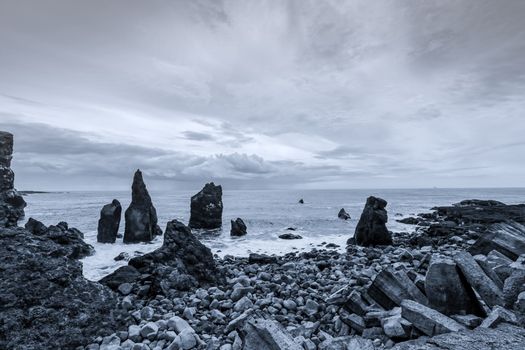 Monochrome image of a rocky coastal seascape capturing the dramatic beauty of nature.