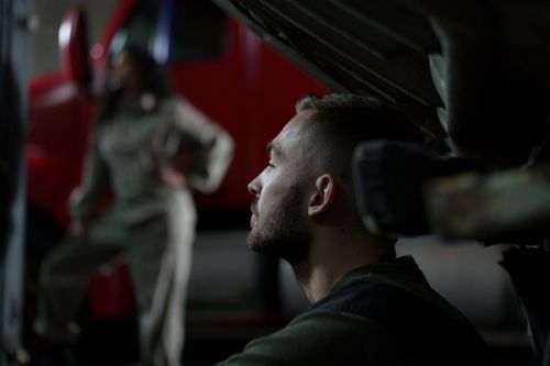 Free Auto mechanic focused on work in a dimly lit garage with blurred background and repair atmosphere. Stock Photo