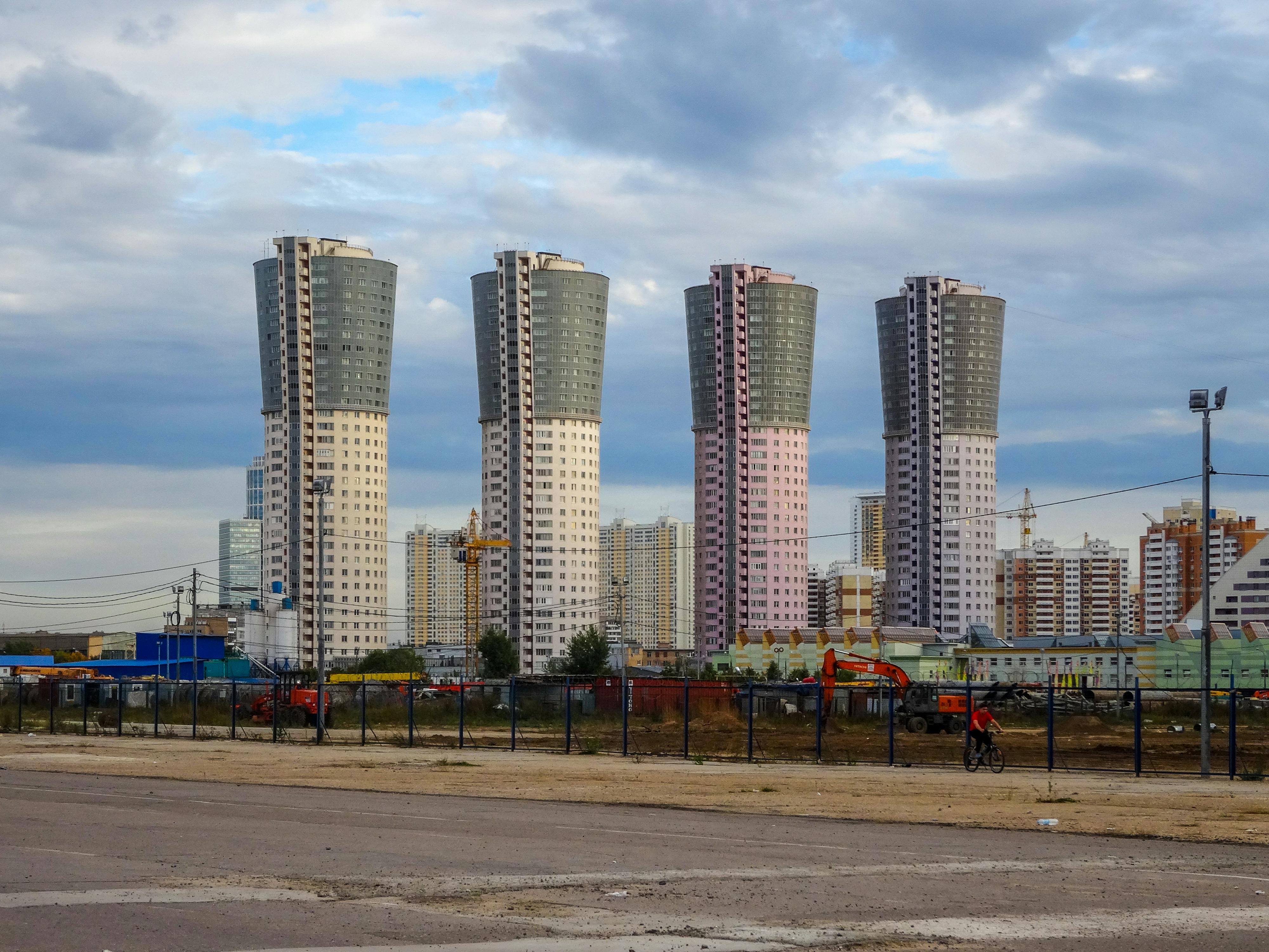 Modern high-rise buildings in Moscow with a cloudy sky backdrop and urban landscape.