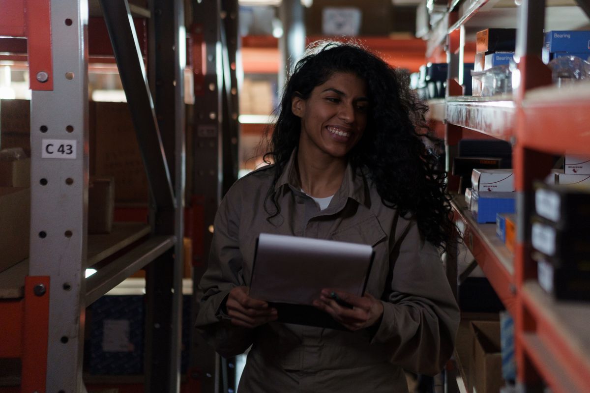 Warehouse worker checking inventory clipboard