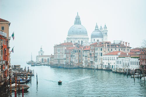 Free Beautiful view of Venice's Grand Canal with Santa Maria della Salute in misty surroundings. Stock Photo