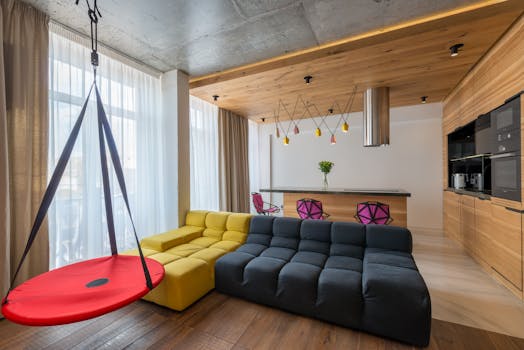 Contemporary stylish interior design of kitchen near resting zone with soft couch and hanging swings