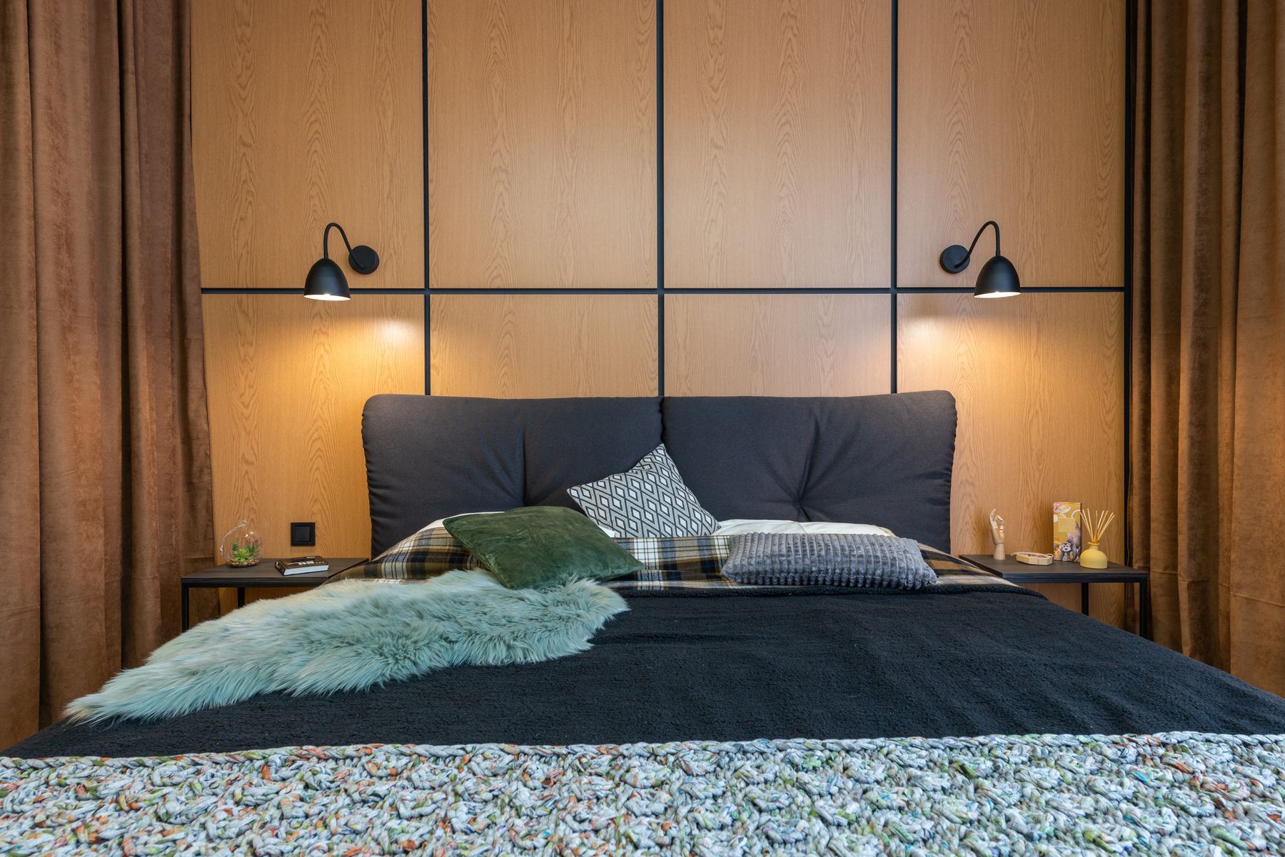 Bedroom with a wood headboard wall, suspended bedside lights and coordinated full-height storage