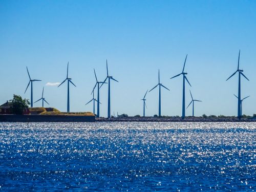Free A scenic view of wind turbines along the coast of Copenhagen against a clear blue sky. Stock Photo