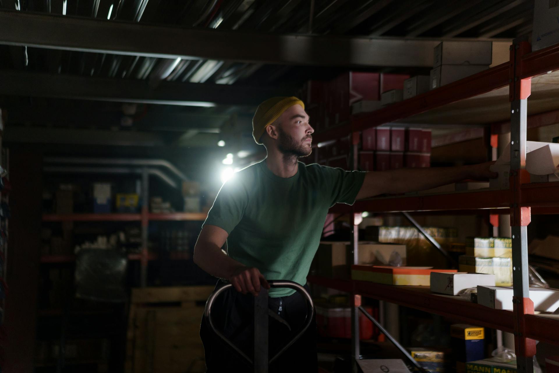 A dedicated worker organizing inventory on warehouse shelves with focused concentration.