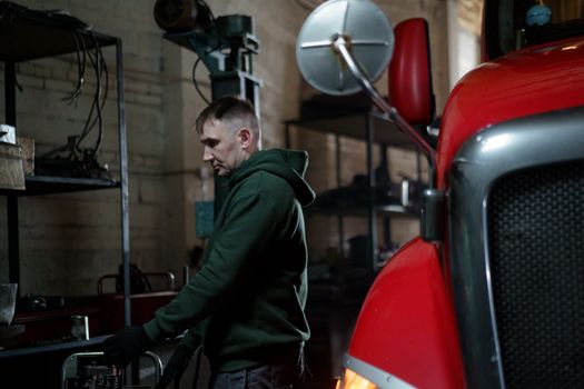 Man in Green Jacket Standing Near Red and Black Exercise Equipment