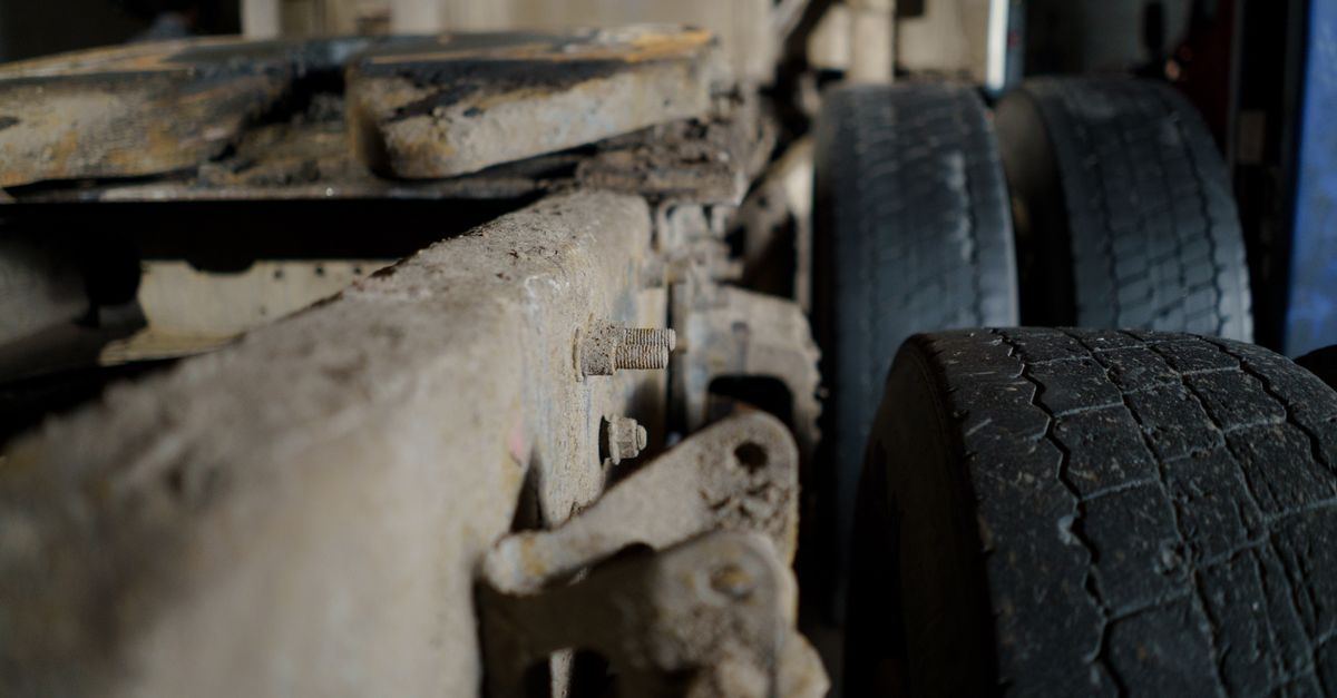 Detailed close-up of a dirty truck chassis and tires, showcasing automotive machinery.