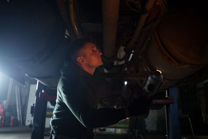 Automotive mechanic servicing a raised vehicle at Auto Servis Grgurovic