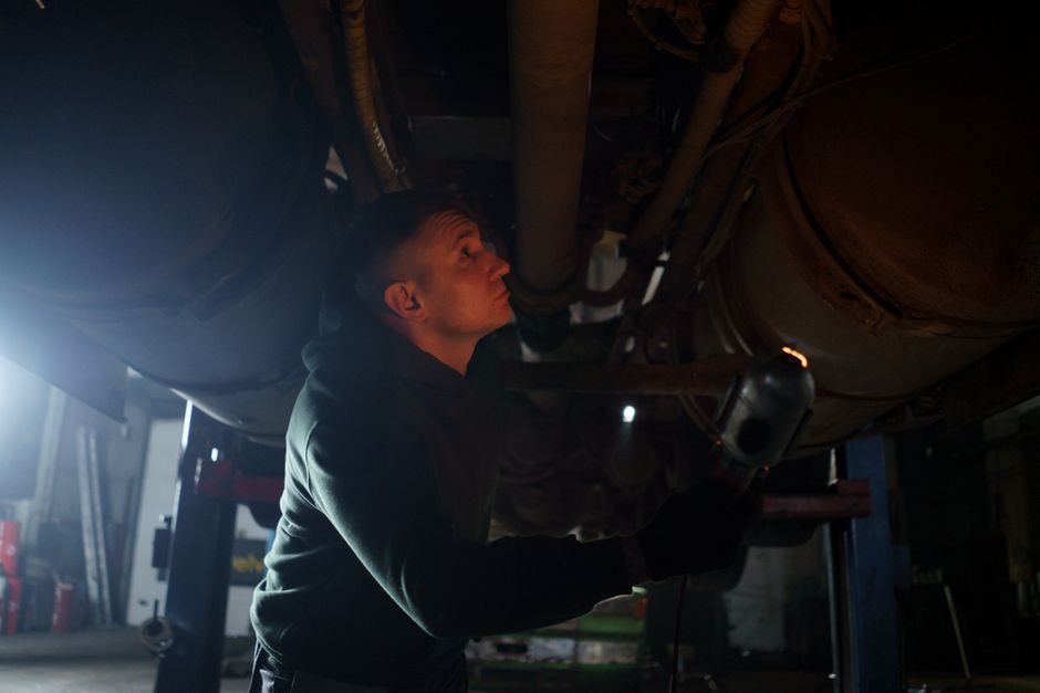 A mechanic inspecting a car in a workshop