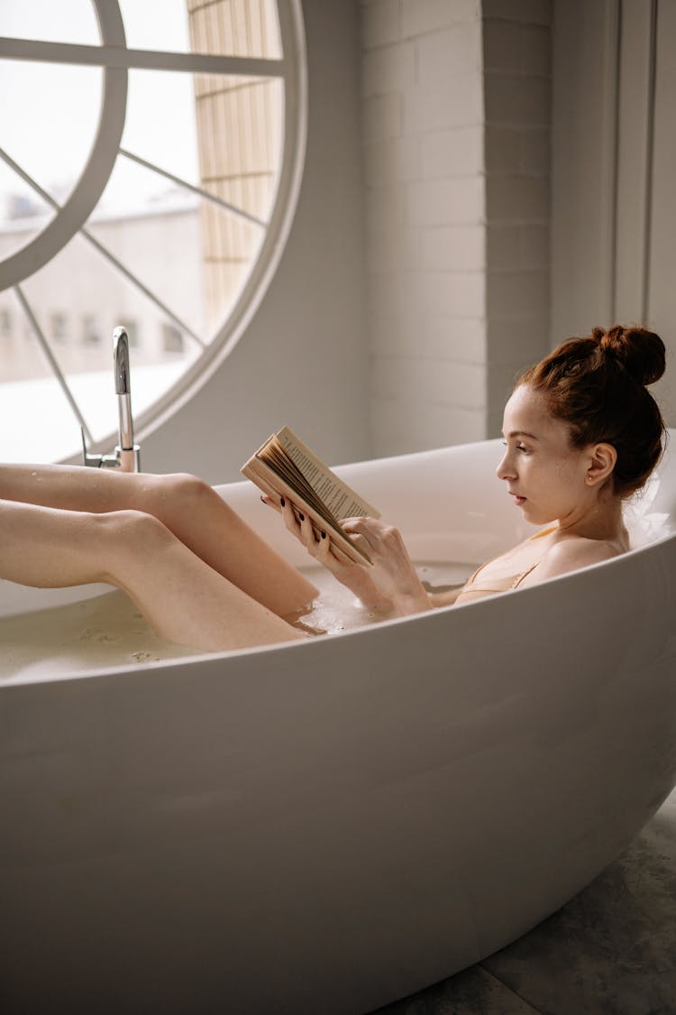 Woman Reading A Book In The Bathtub
