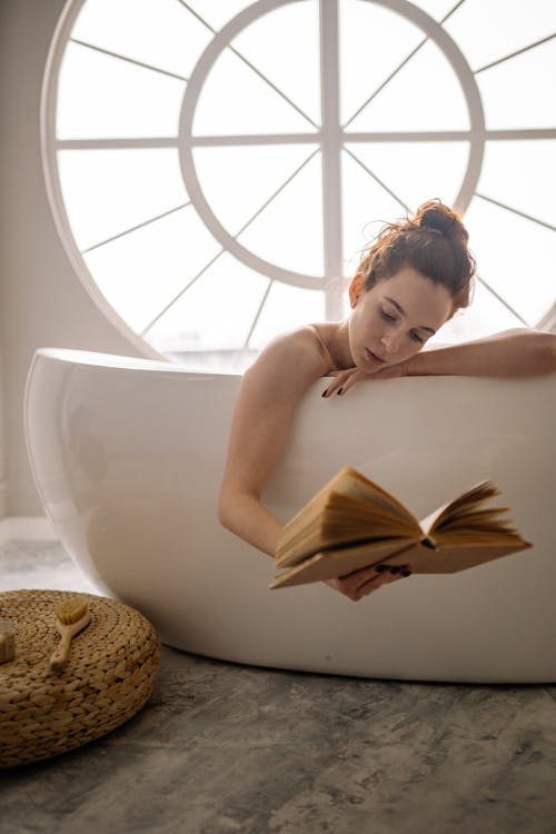 Woman Reading a Book White in a Bathtub