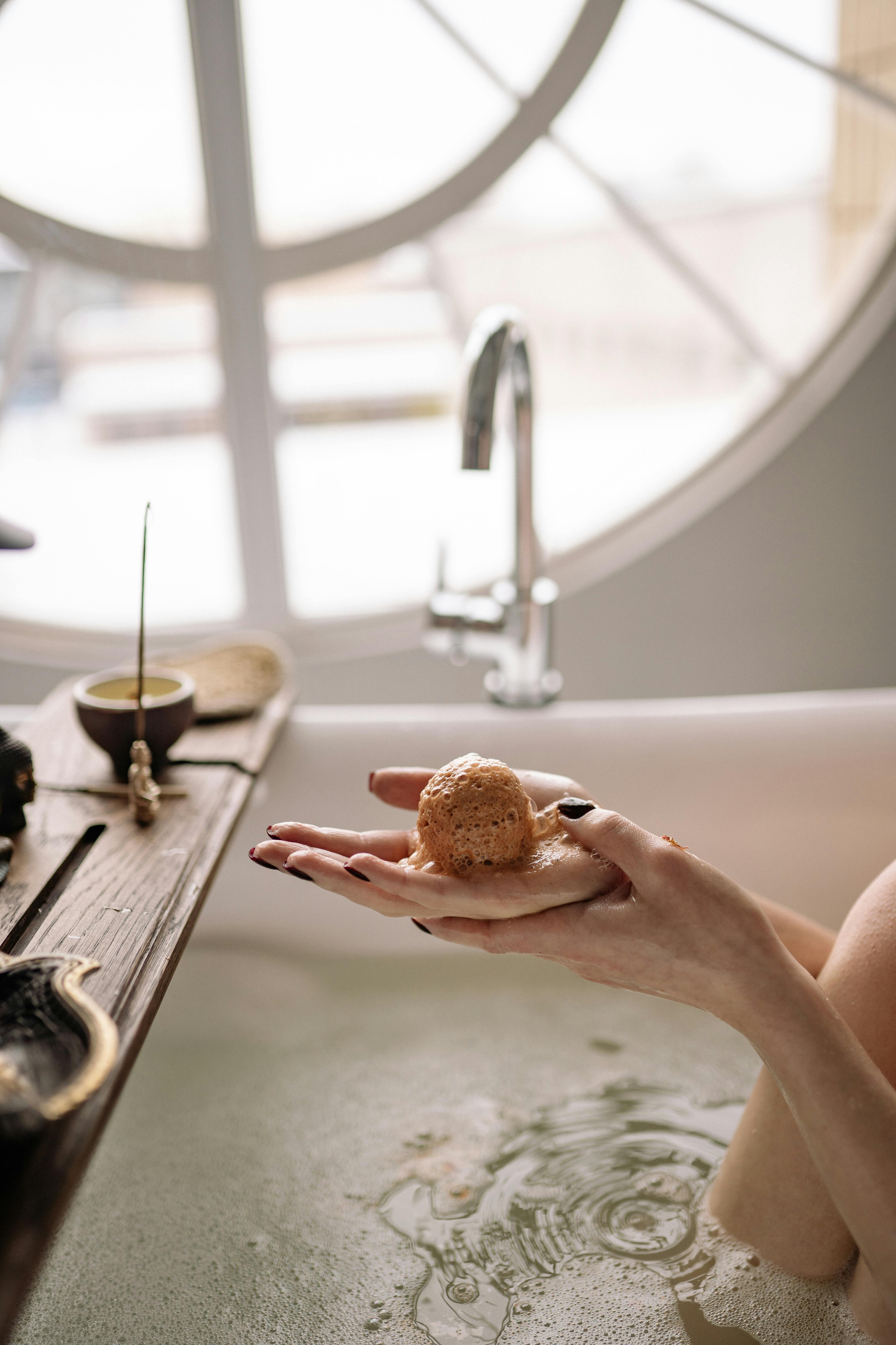 A serene moment in a bathtub featuring a bath bomb and candles, fostering relaxation and self-care.