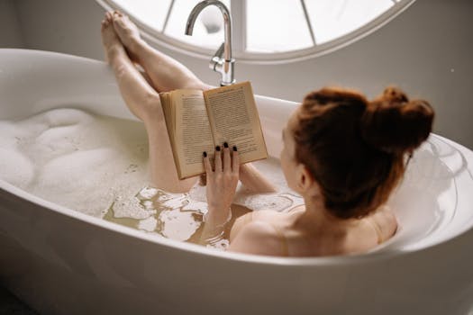 A woman enjoys a peaceful bath, reading a book in a serene bathroom setting.