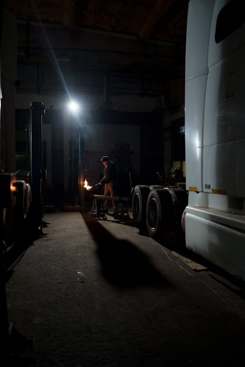 Man in Black Jacket Standing Near White Truck