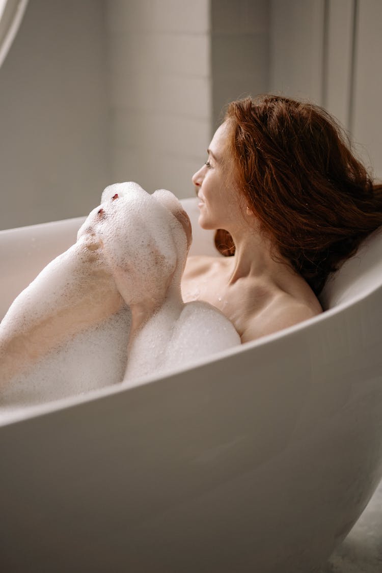 Photo Of A Woman Taking A Bath In A Bathtub With Bubbles