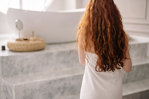 Back View of a Woman Going to the Bathtub