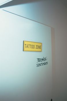 Door with Yellow Placard and Words Written in Black Marker