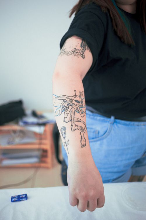 Free A close-up view of a creative tattoo design on a woman's arm against an indoor background. Stock Photo