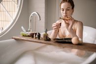 Woman in Bathtub Holding Toothbrush