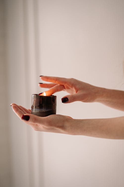 A Person Holding a Burning Candle 