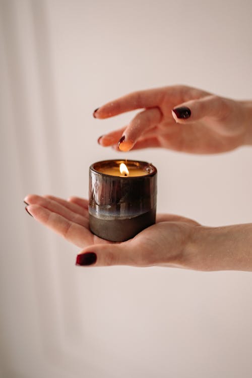 A Lit Candle on a Hand 