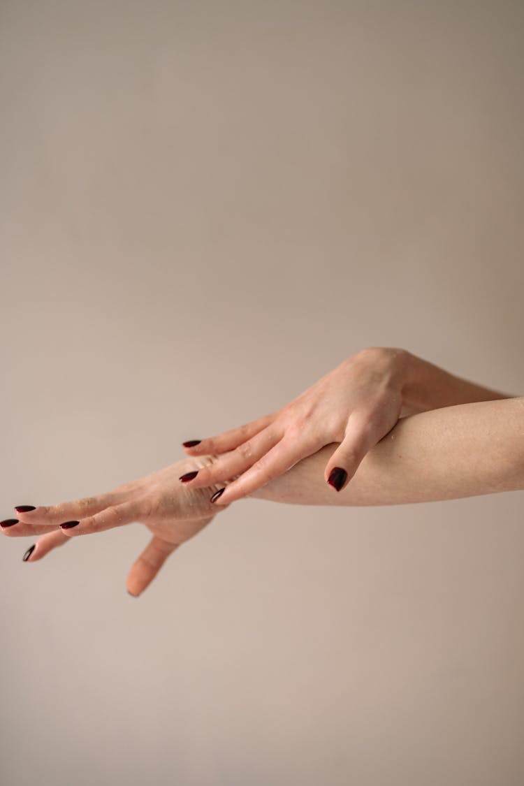 Photo Of A Person With Nail Polish Touching Her Arm