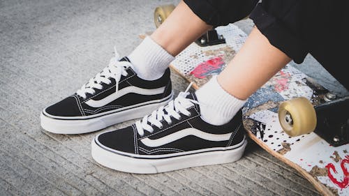 Free Close-Up Photo of a Person Wearing Black and White Sneakers Stock Photo