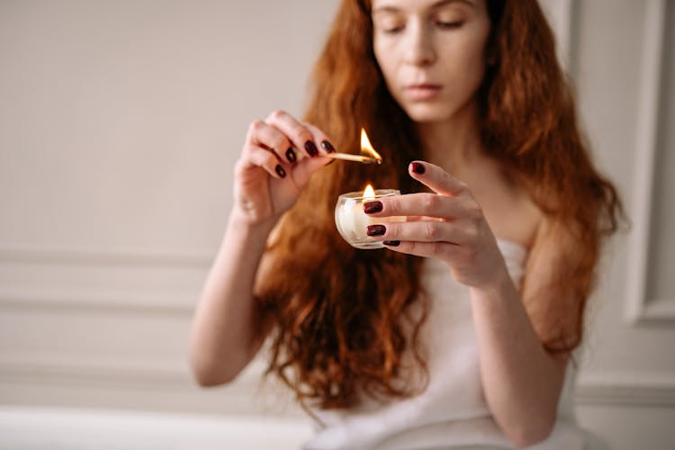 Woman Lighting A Candle 