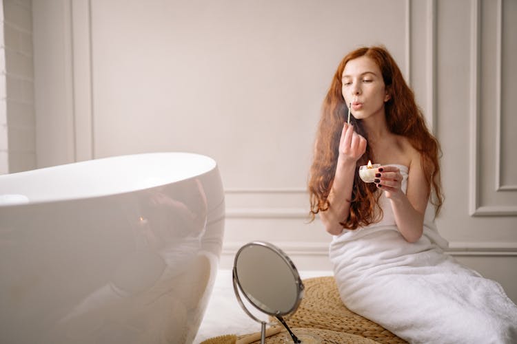 Photo Of A Woman With Red Hair Blowing A Matchstick