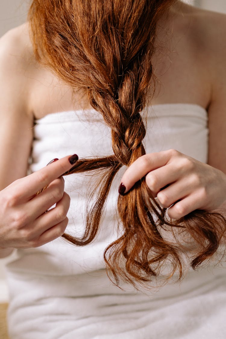 Woman Braiding Her Hair 