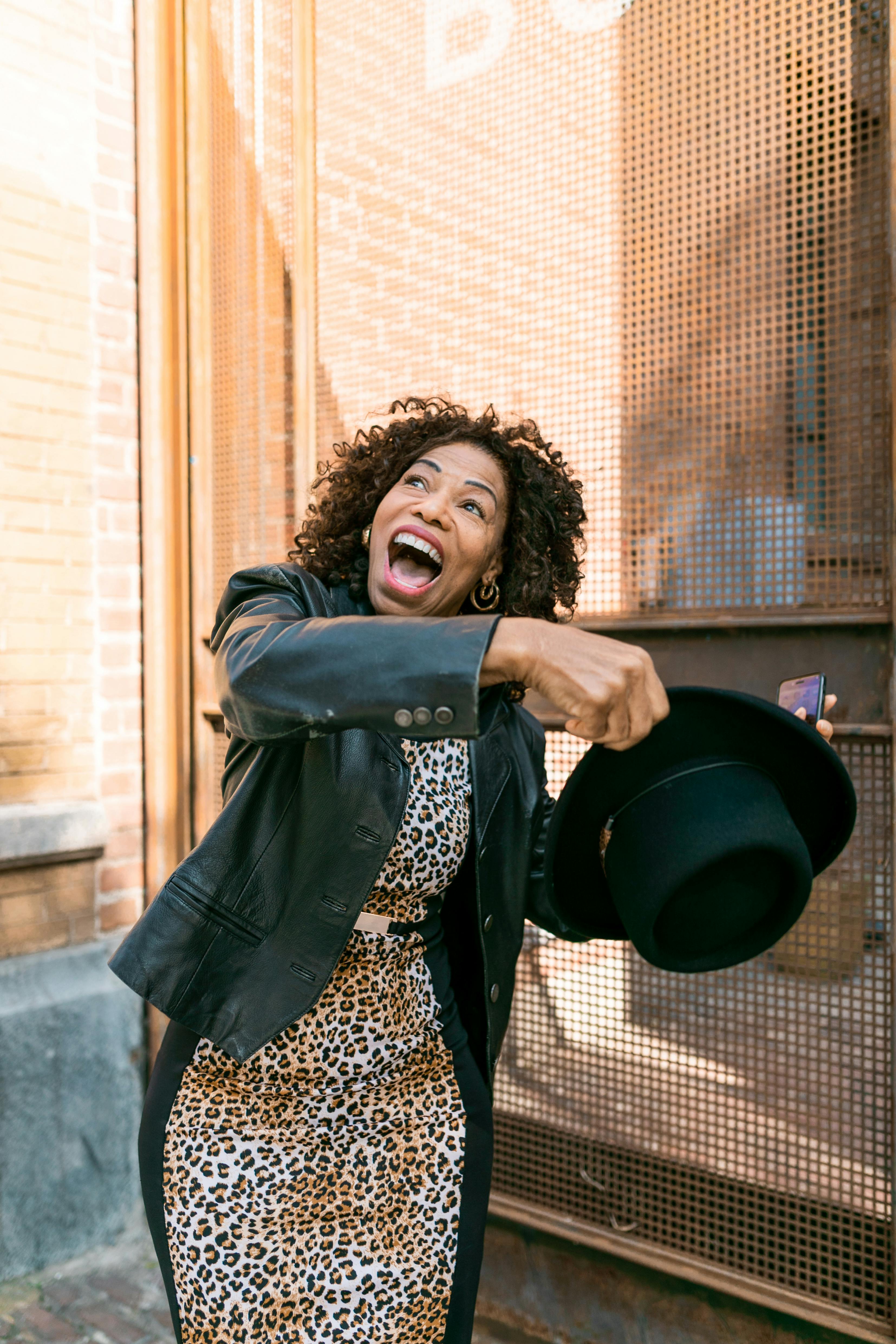 woman in black leather jacket holding black hat