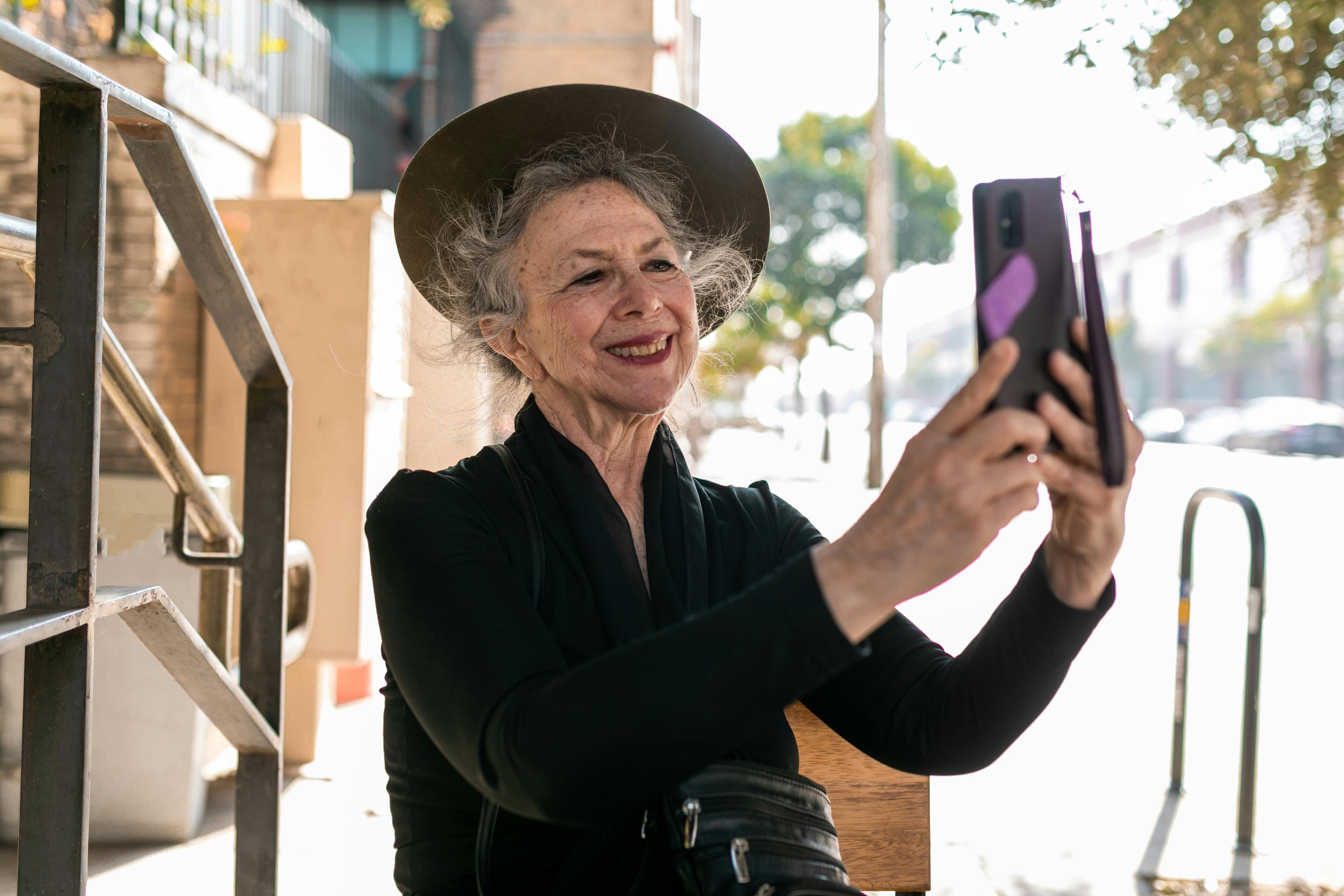 elderly woman in black taking a selfie