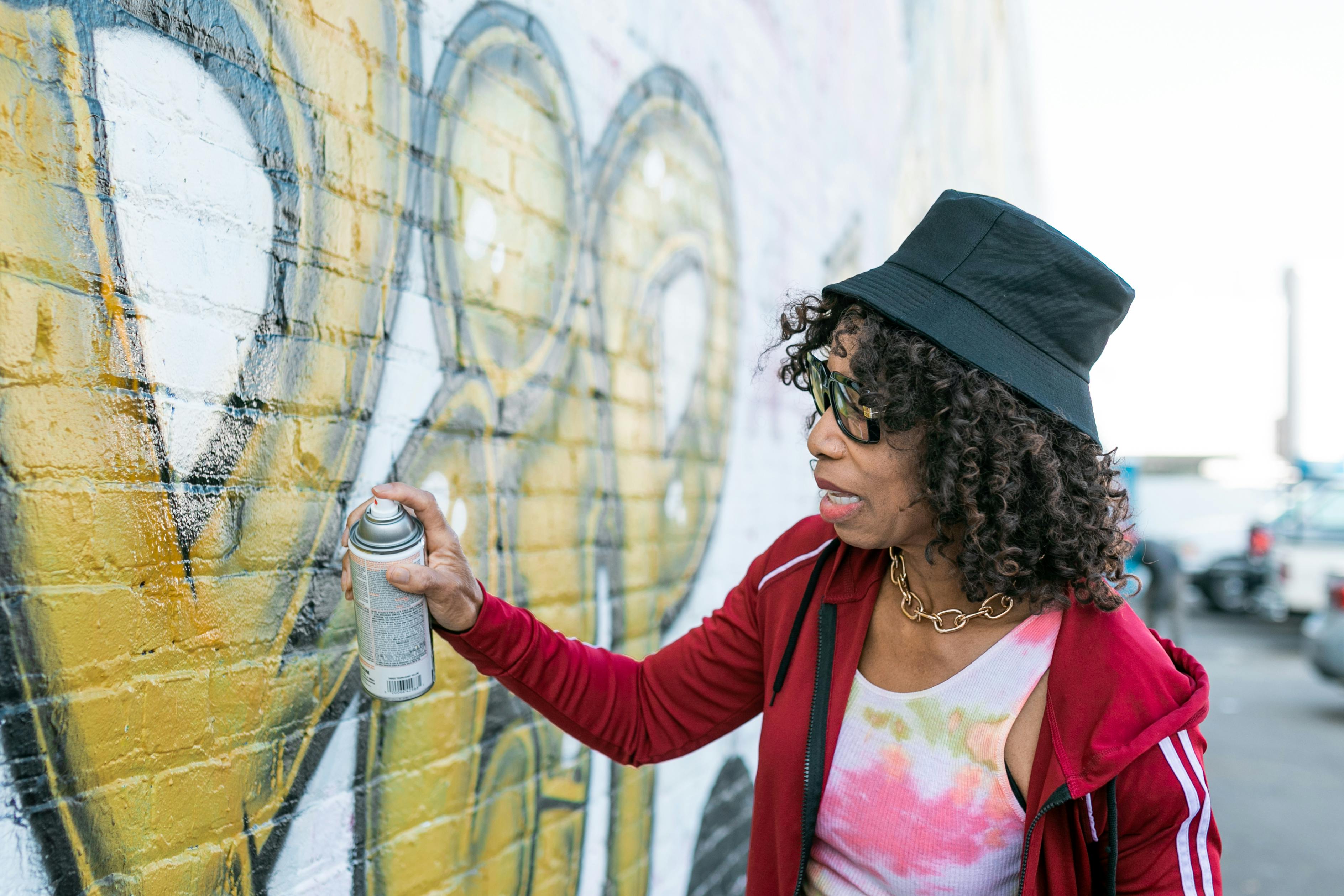 woman putting spray paint on wall