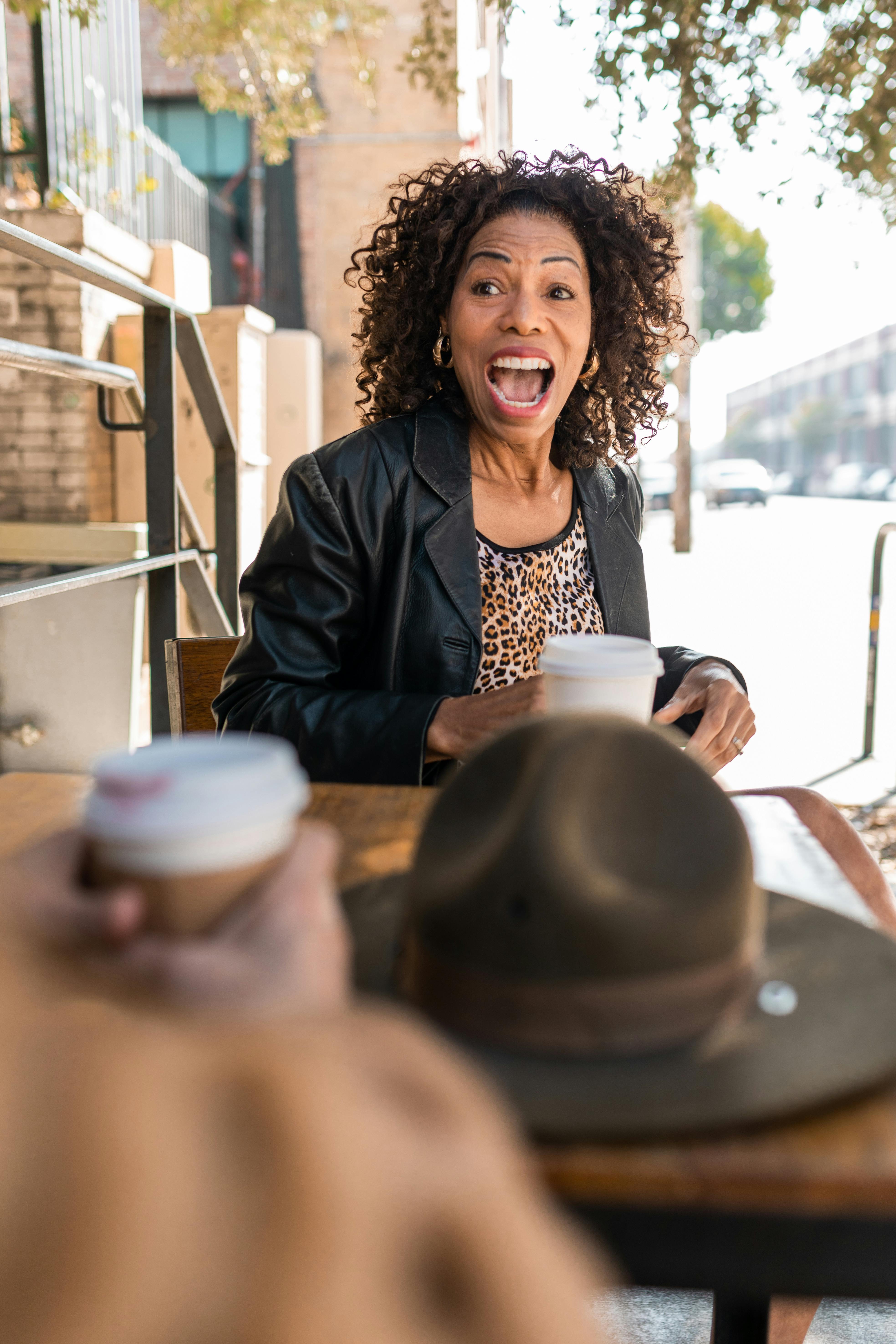 woman in black blazer sitting by the table