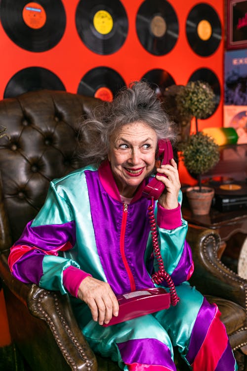 Elderly Woman Sitting on Brown Leather Chair Using Telephone