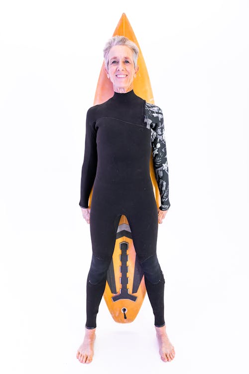 Woman in Black Swimwear Holding A Surfboard