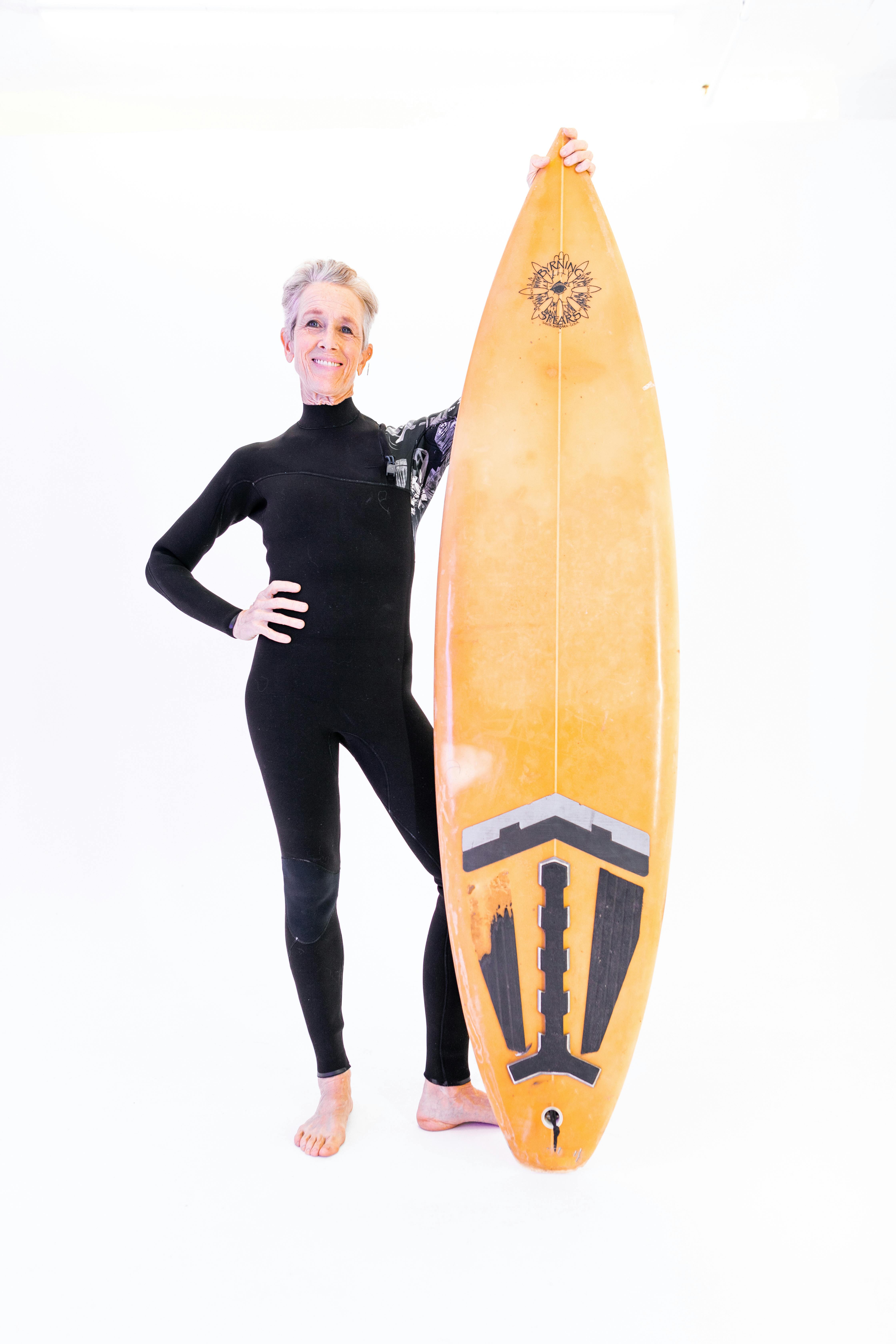 woman standing beside a surfboard