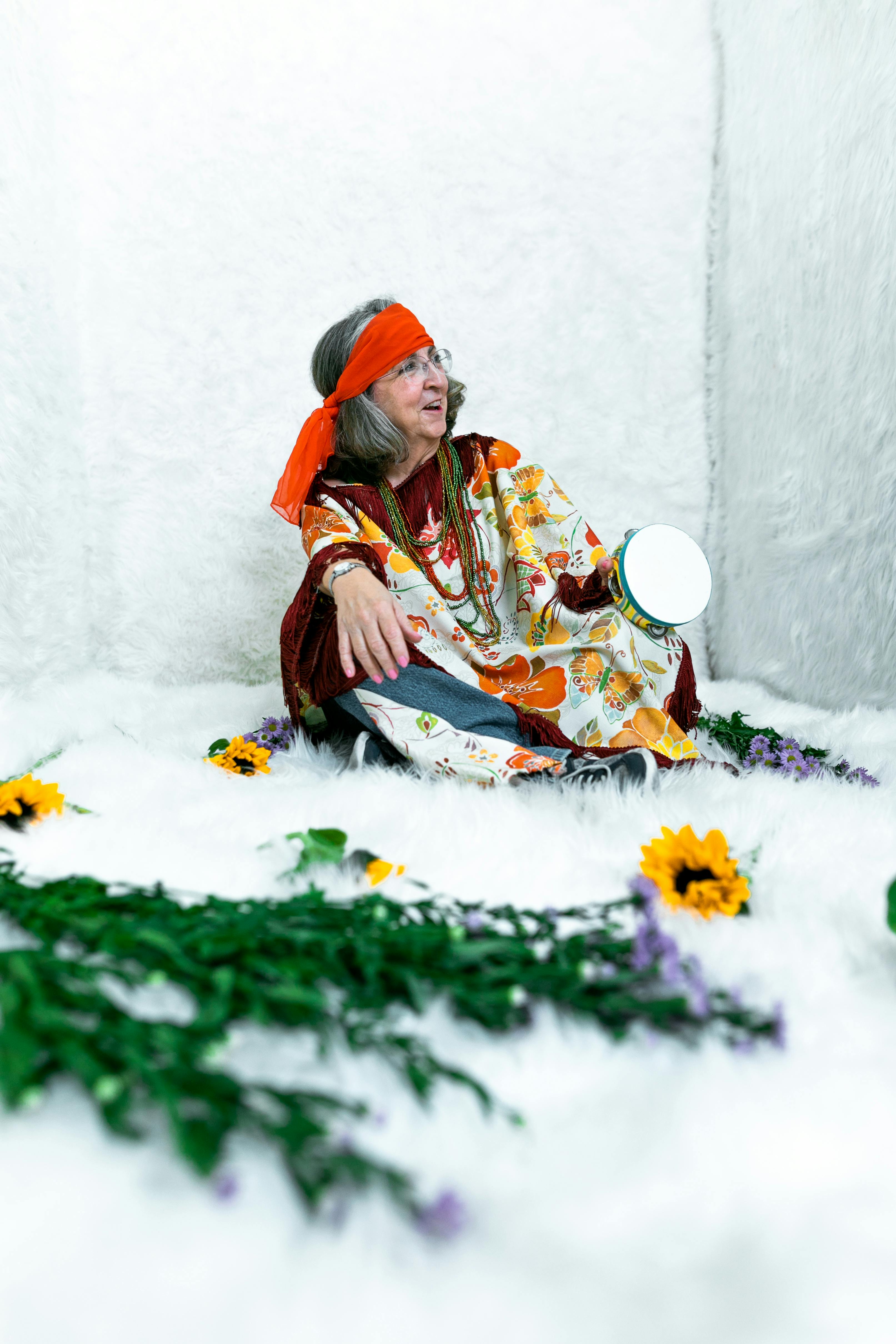 woman in orange and white dress sitting on white snow covered ground