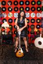 Woman in Black Sleeveless Shirt Standing With A Guitar