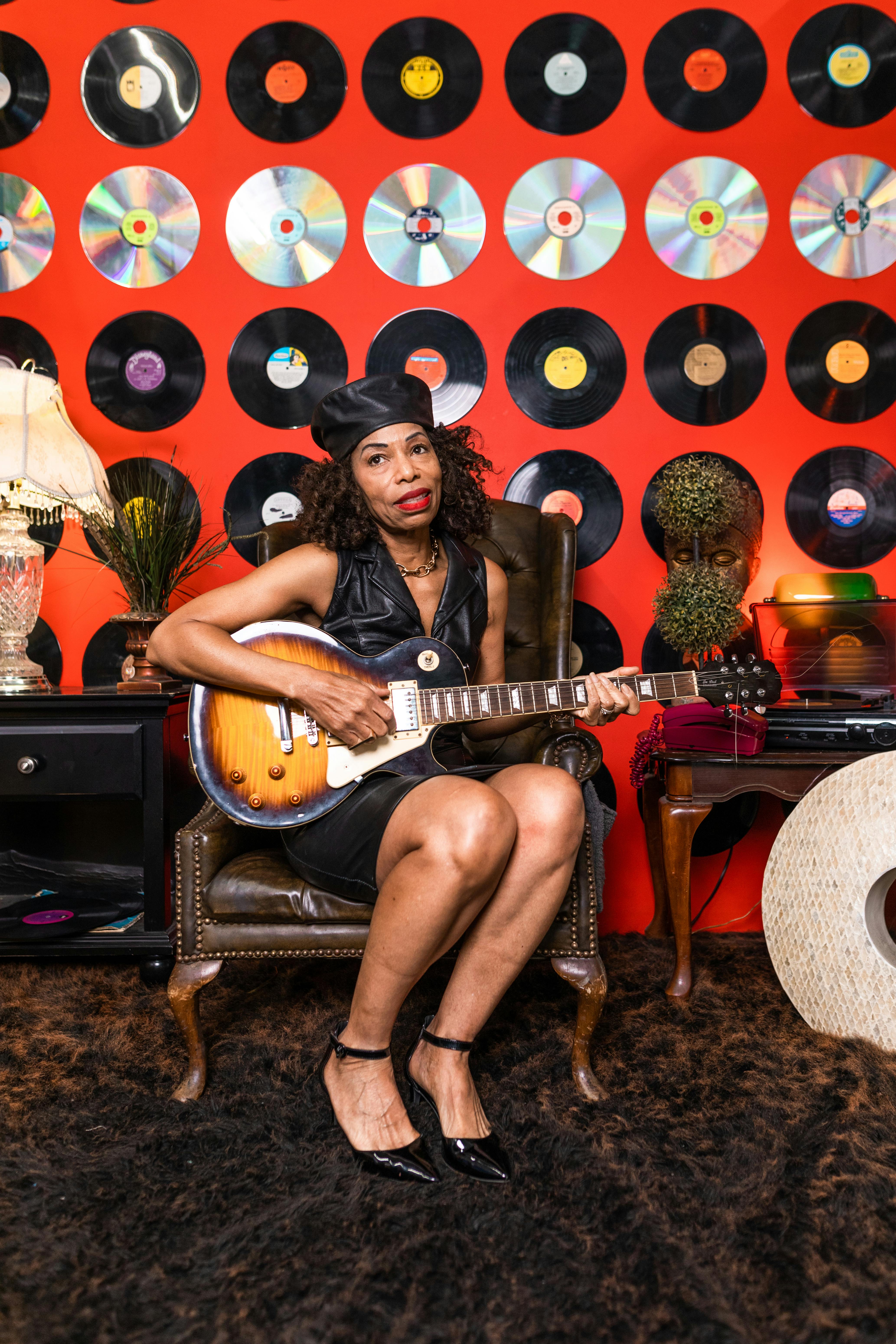 woman in black dress playing guitar