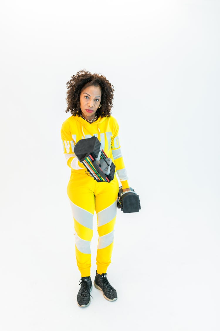 Woman In Yellow Active Wear Carrying Weights