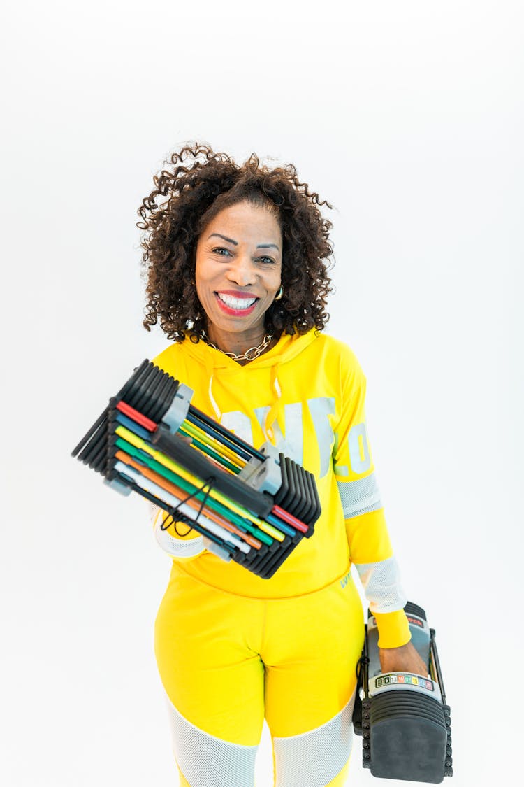 Woman In Yellow Sportswear Carrying Weights