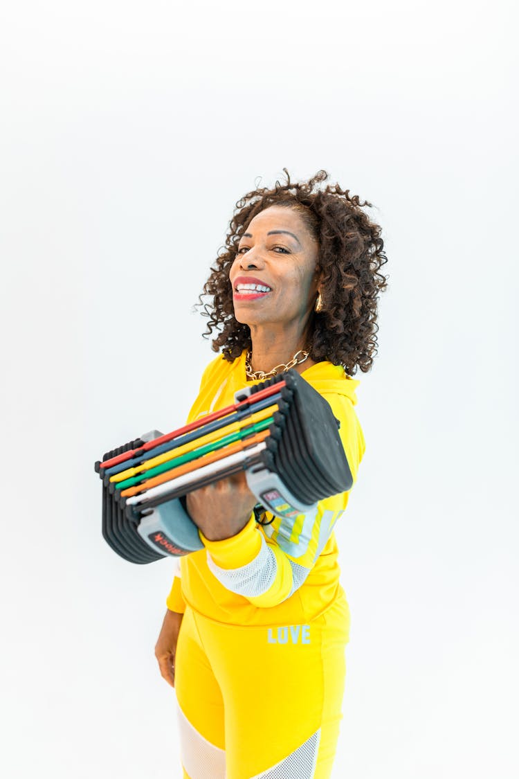 Woman In Yellow Sports Wear Carrying Weights