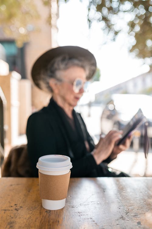 Free Elderly Woman Sitting By The Table With A Cup Of Coffee Stock Photo
