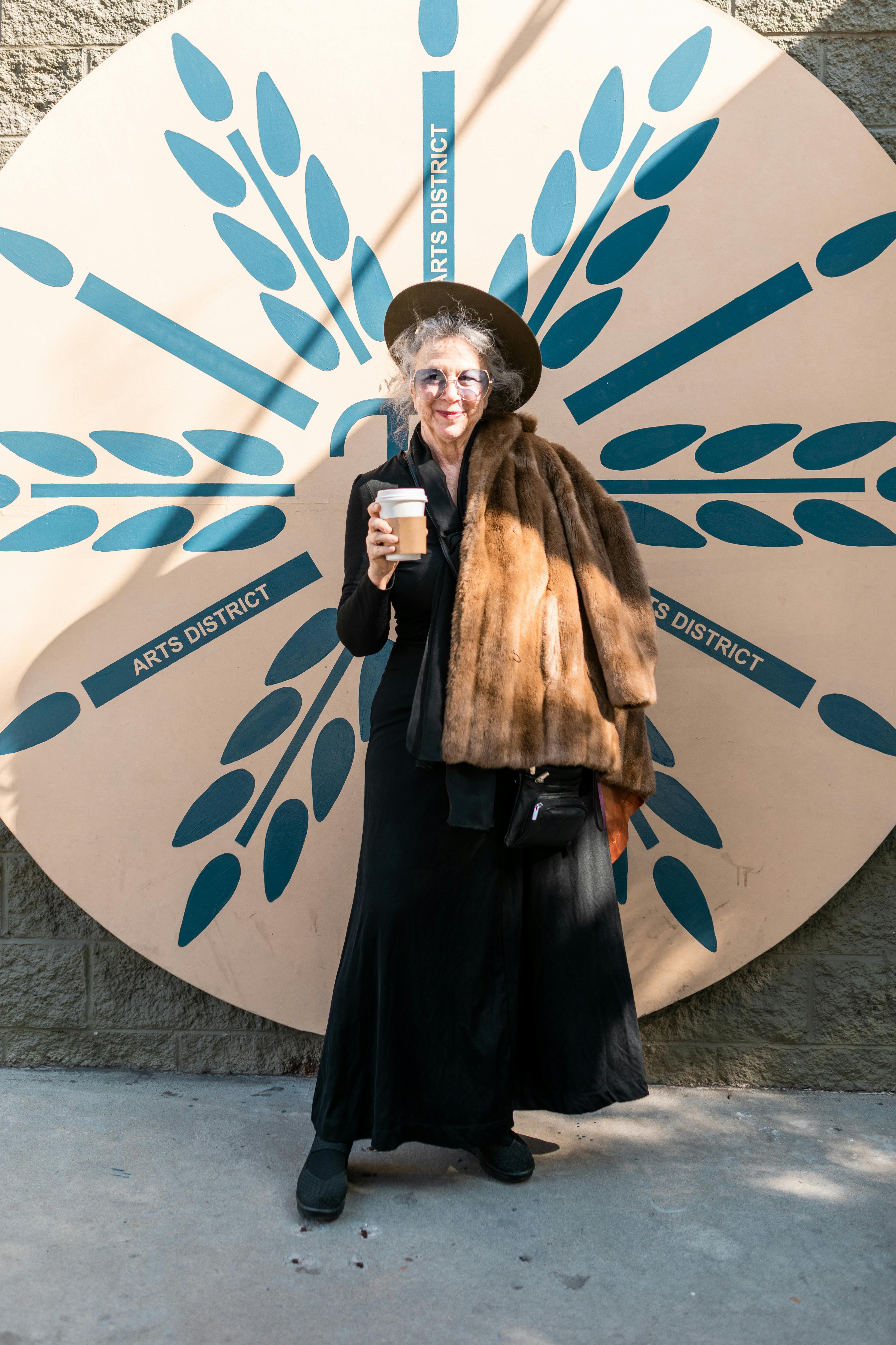 woman in black dress holding a coffee cup