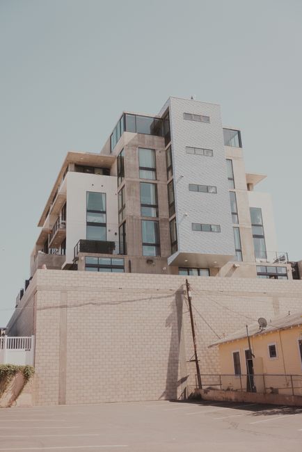 Contemporary apartment building with glass windows under a clear sky.