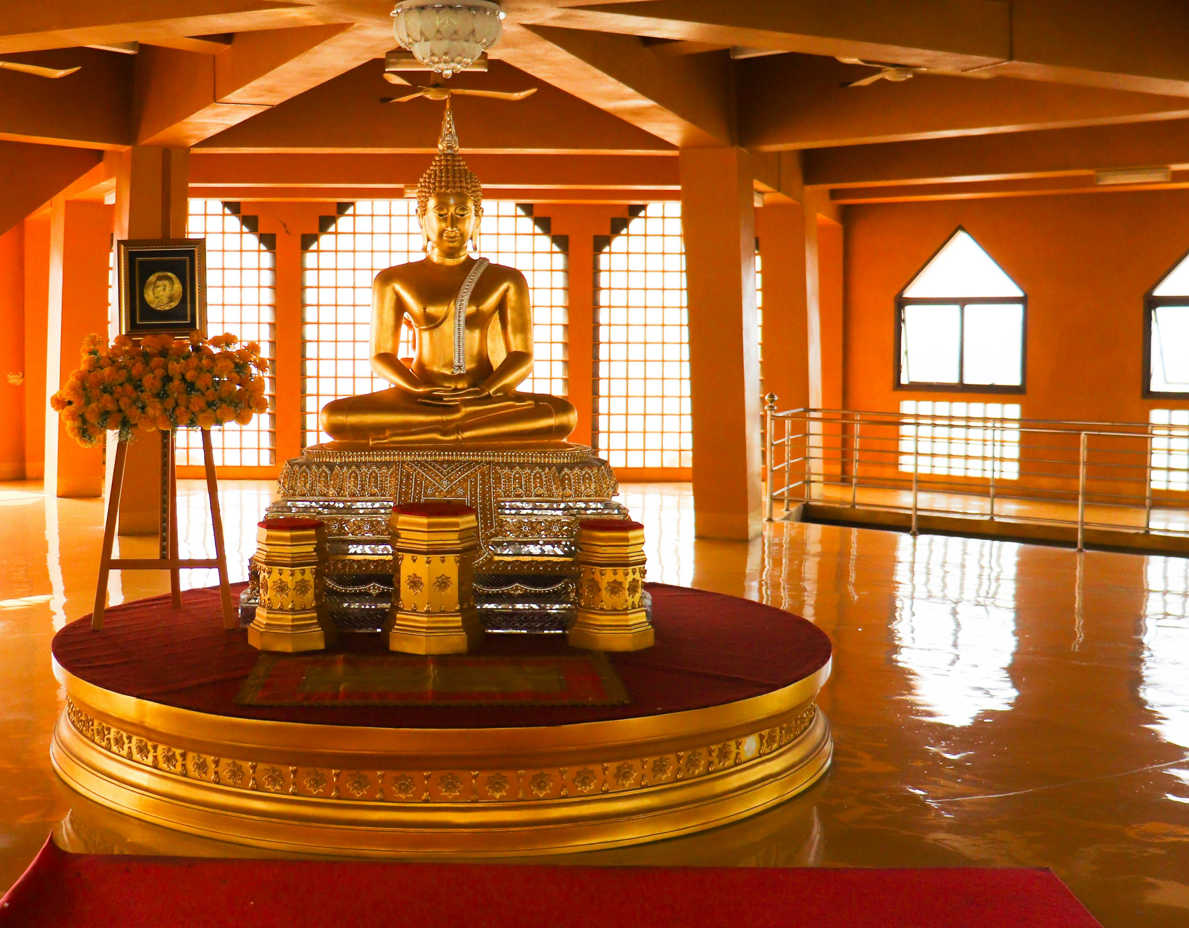 golden buddha statue in spacious oriental temple