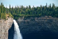 郁郁葱葱的常绿森林环绕的岩石悬崖上，跌落下令人惊叹的瀑布