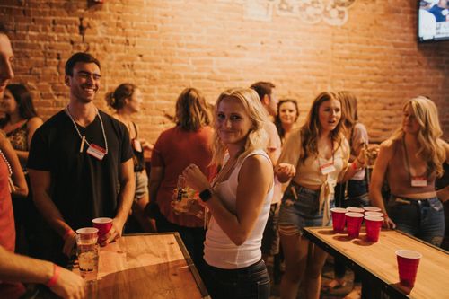 Free Group of young adults enjoying drinks and games at a lively Denver pub. Stock Photo