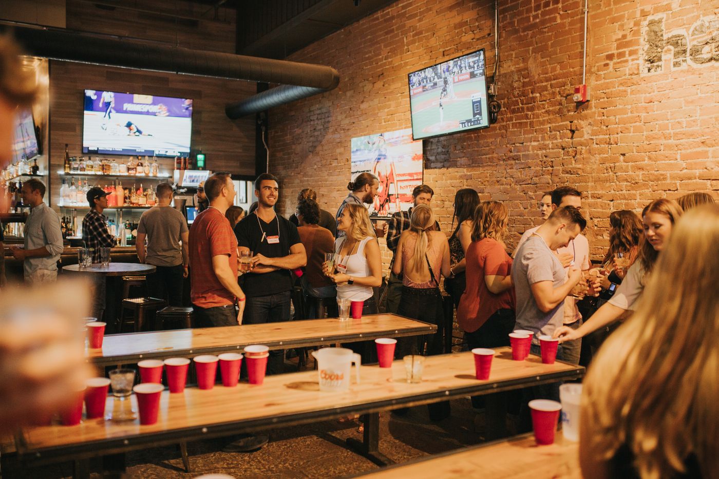 American sports fans watching a live game together in a busy Denver sports bar